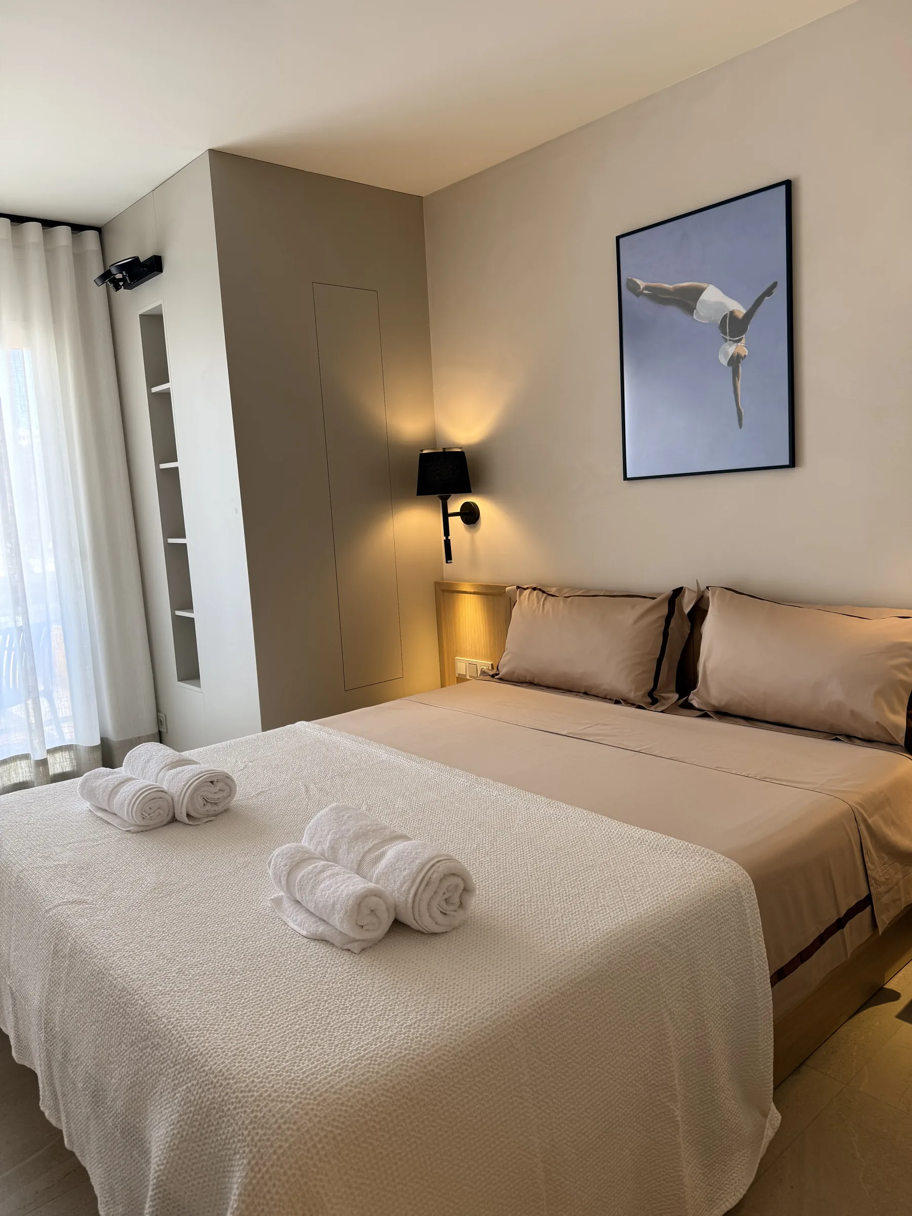 Dormitorio de invitados con cama de matrimonio y mesillas de roble en un ático reformado en Platja d'Aro